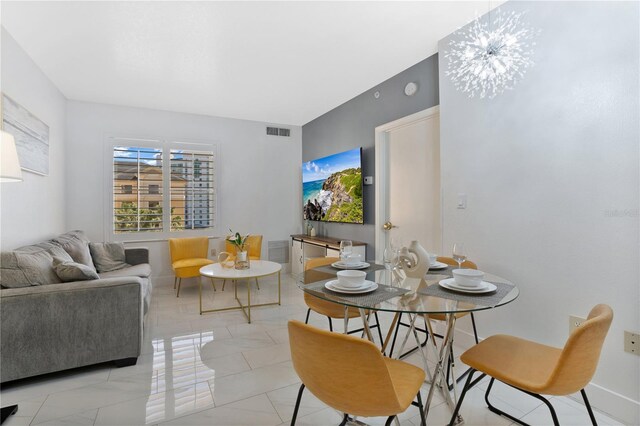 tiled dining area with a chandelier