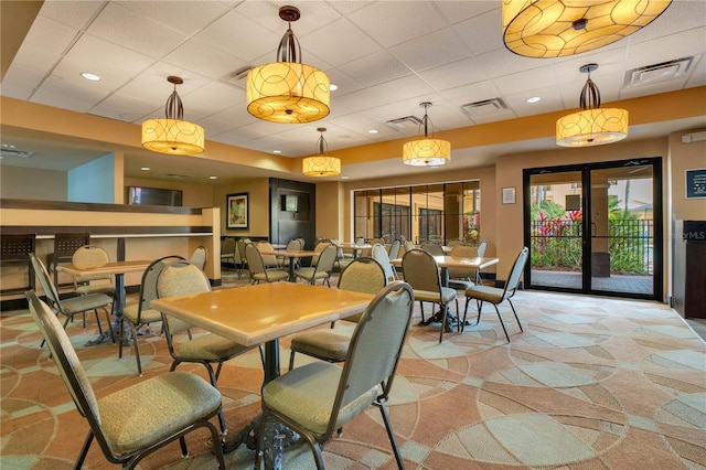 dining space featuring a paneled ceiling and french doors