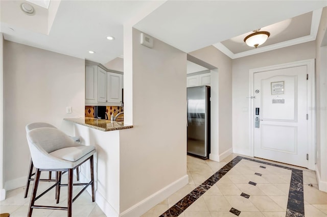 foyer featuring crown molding and light tile patterned floors