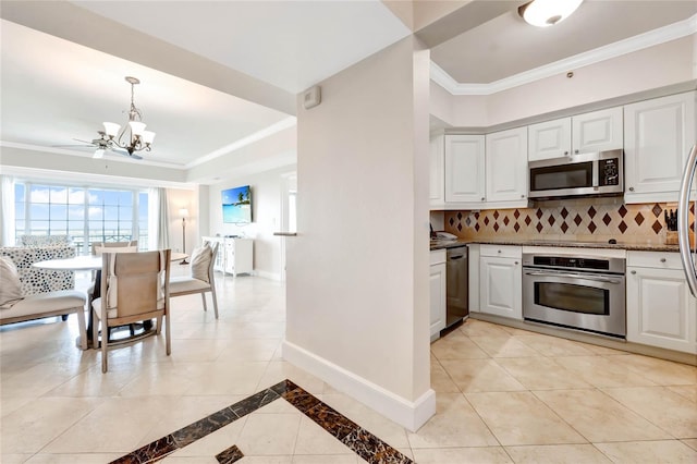 kitchen with crown molding, white cabinetry, stainless steel appliances, and an inviting chandelier