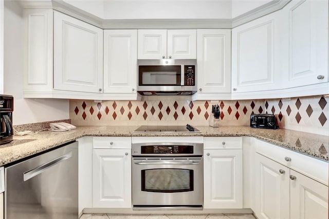kitchen featuring appliances with stainless steel finishes, decorative backsplash, light stone countertops, and white cabinetry