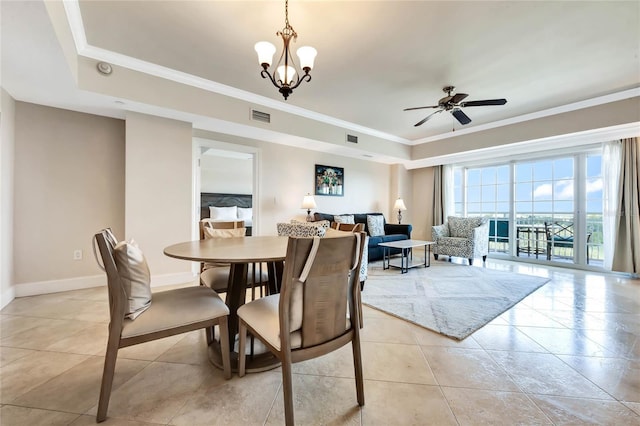 dining room featuring a ceiling fan, a tray ceiling, visible vents, baseboards, and ornamental molding