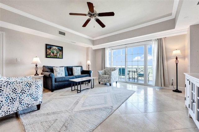 living area featuring baseboards, ceiling fan, ornamental molding, and visible vents