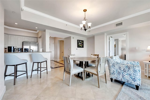 tiled dining space with an inviting chandelier, a tray ceiling, and crown molding