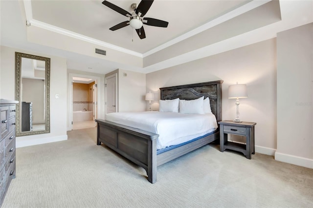 carpeted bedroom featuring a raised ceiling, ceiling fan, and ensuite bathroom