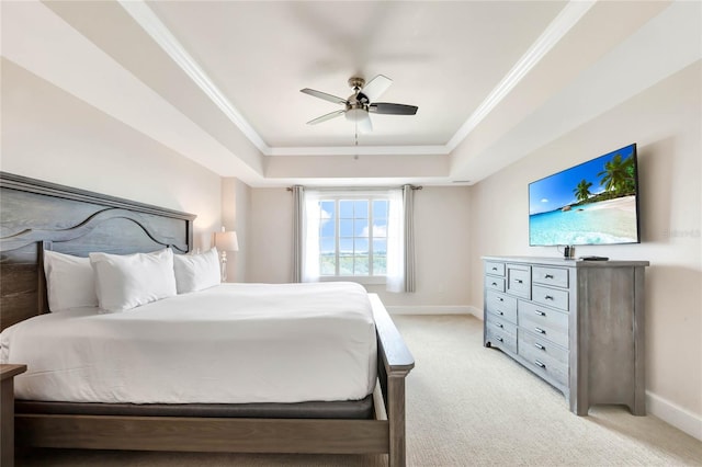 bedroom featuring a tray ceiling, ornamental molding, ceiling fan, and light colored carpet