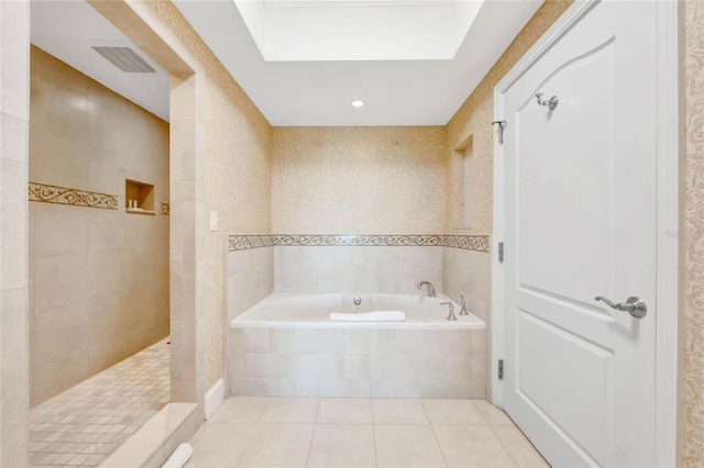 bathroom with a skylight, plus walk in shower, and tile patterned floors