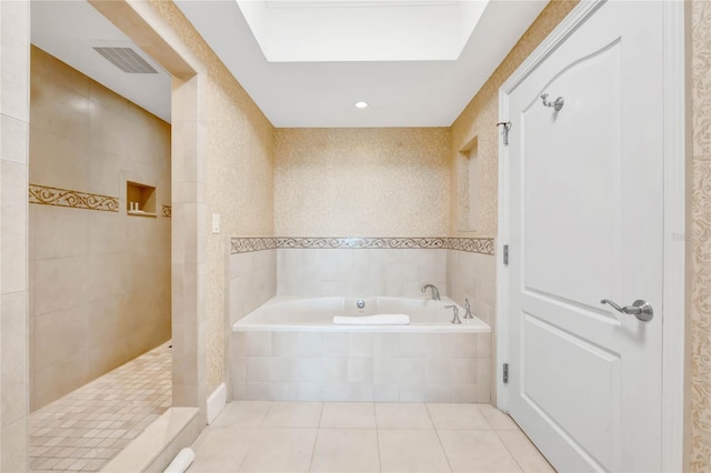 full bathroom featuring a walk in shower, tile walls, a bath, visible vents, and tile patterned flooring