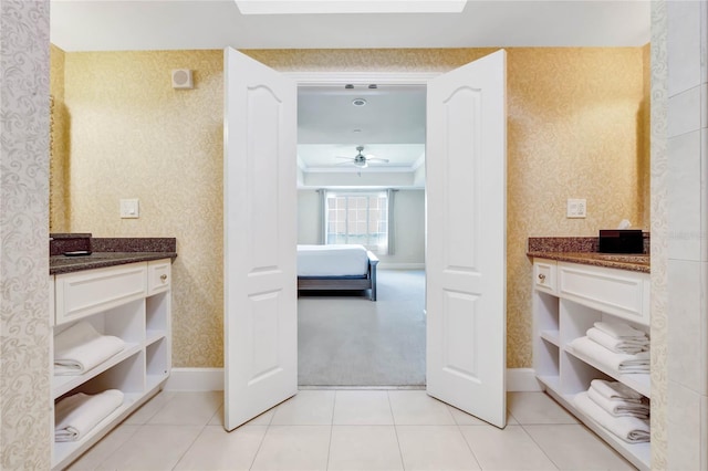 hall featuring light carpet, baseboards, light tile patterned floors, and wallpapered walls