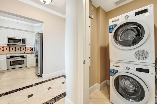 clothes washing area with light tile patterned floors, crown molding, and stacked washer / drying machine