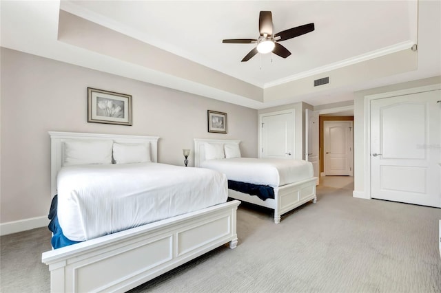 bedroom featuring a ceiling fan, visible vents, baseboards, a raised ceiling, and light carpet