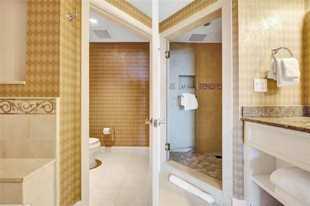 bathroom with a tile shower, toilet, tile patterned floors, and visible vents