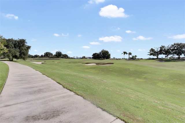 view of community with a lawn and golf course view