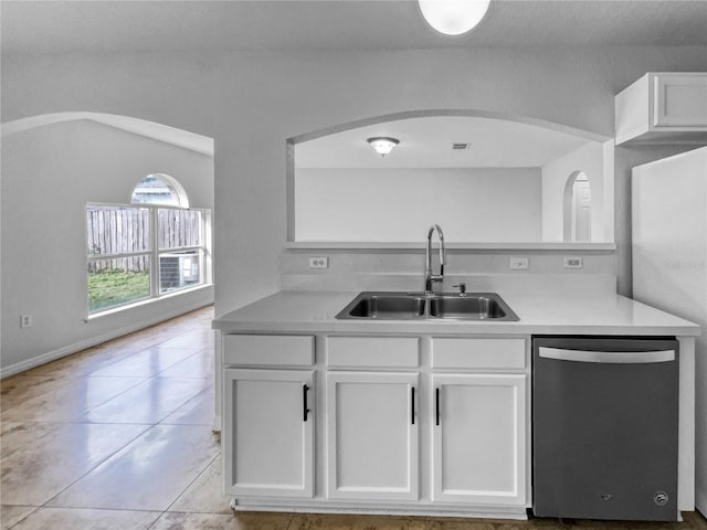 kitchen with light tile patterned floors, white cabinets, dishwasher, and sink