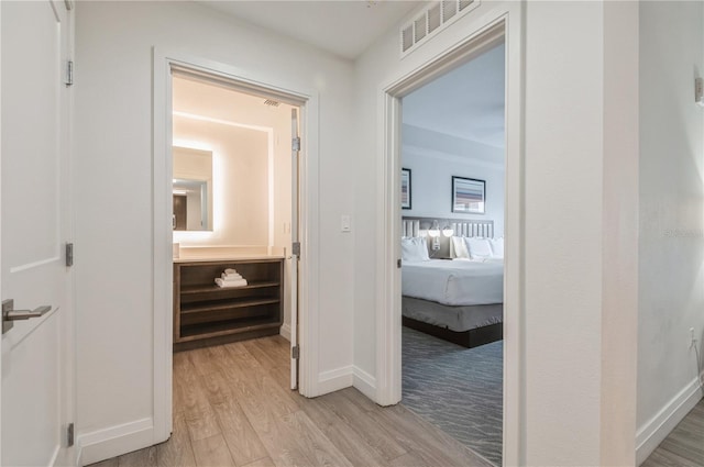 corridor with light hardwood / wood-style flooring