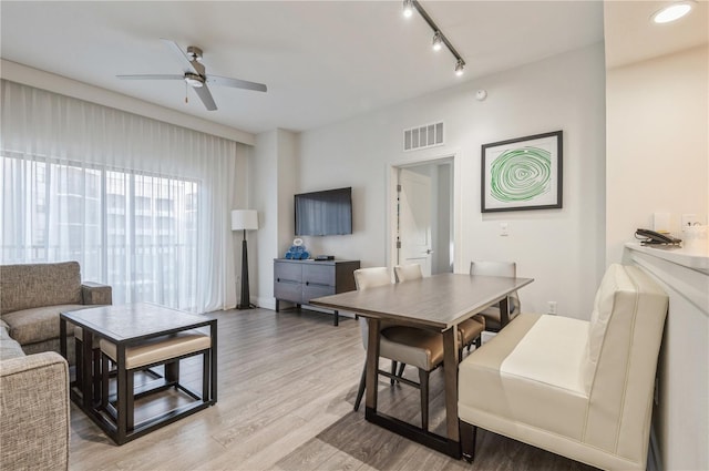 interior space featuring rail lighting, light hardwood / wood-style floors, and ceiling fan