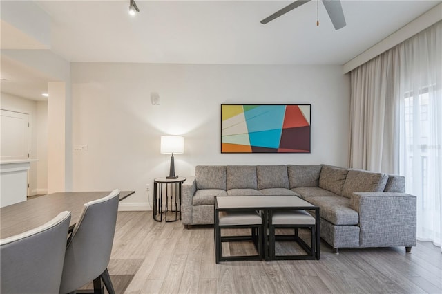 living room featuring light hardwood / wood-style floors and ceiling fan