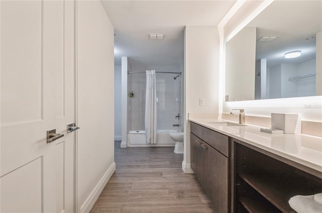 full bathroom featuring toilet, vanity, tiled shower / bath combo, and wood-type flooring