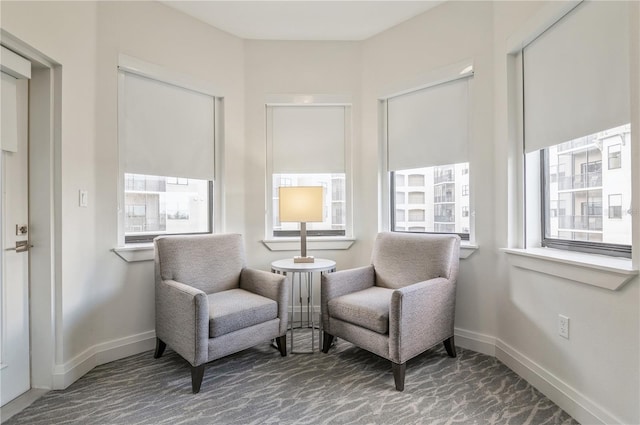 sitting room with dark carpet and a wealth of natural light