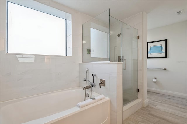 bathroom featuring shower with separate bathtub and plenty of natural light