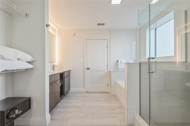 bathroom featuring large vanity and separate shower and tub