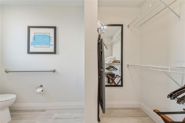 bathroom with toilet and hardwood / wood-style floors