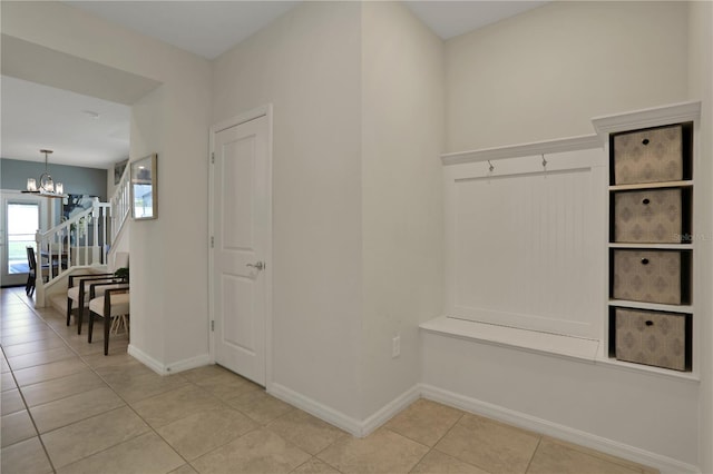 mudroom with a chandelier and light tile floors