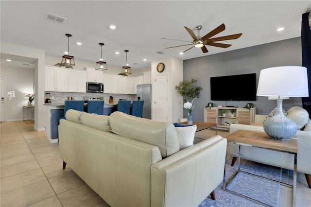 living room with light tile floors and ceiling fan