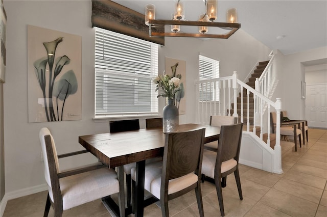 tiled dining room with a notable chandelier