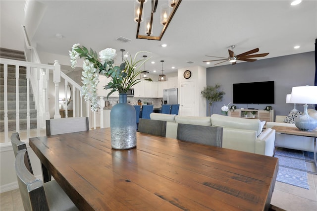 dining area with ceiling fan with notable chandelier