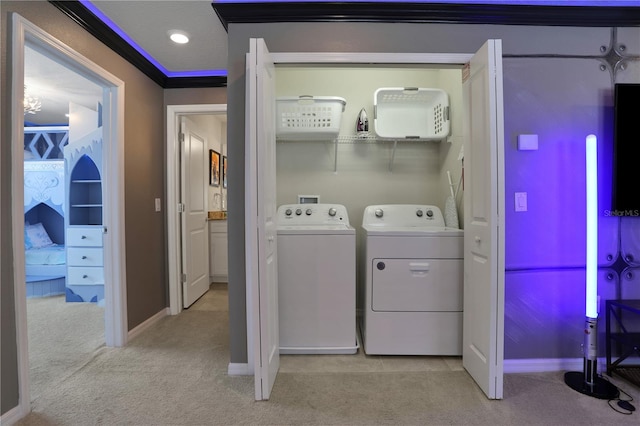 clothes washing area featuring washer hookup, washing machine and dryer, crown molding, and light colored carpet