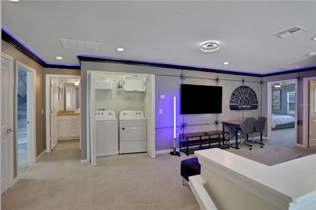 carpeted living room with washer and dryer, ornamental molding, and a textured ceiling