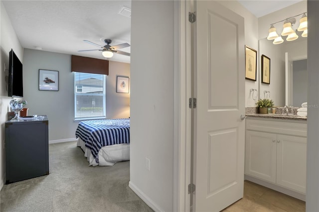 carpeted bedroom with ceiling fan and sink