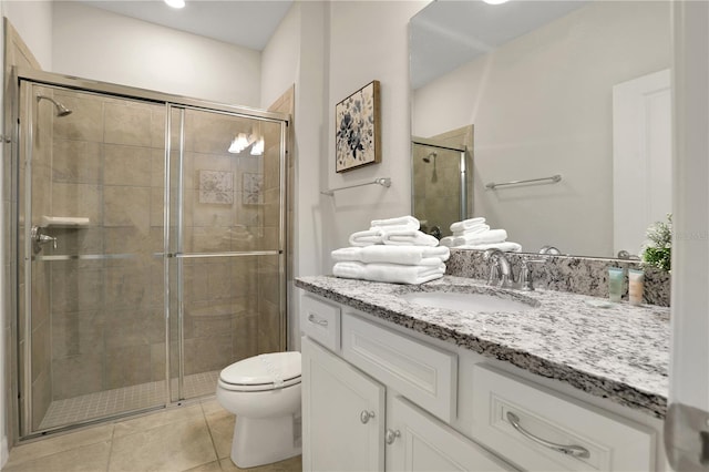 bathroom with vanity, tile flooring, a shower with door, and toilet