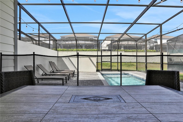 view of pool with glass enclosure and a patio