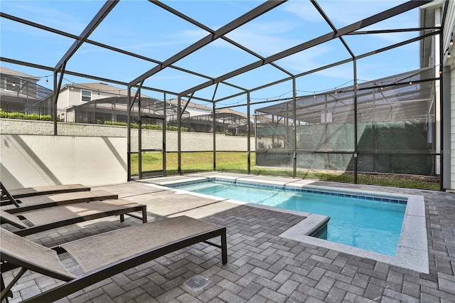 view of swimming pool featuring a lanai, a lawn, and a patio area