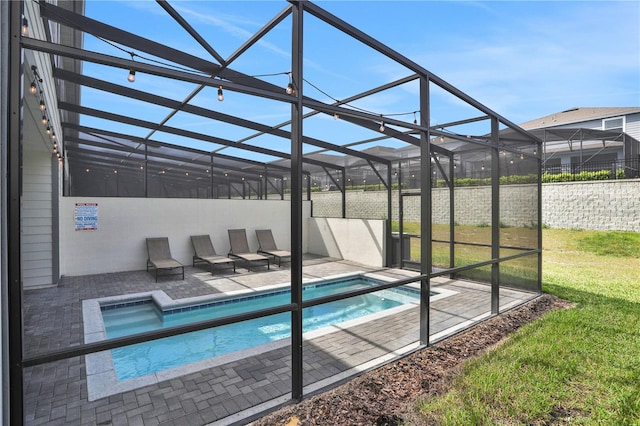 view of swimming pool featuring a patio, glass enclosure, and a yard