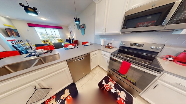 kitchen with appliances with stainless steel finishes, tasteful backsplash, white cabinetry, sink, and light tile floors