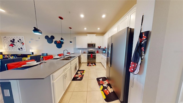 kitchen with decorative light fixtures, stainless steel appliances, white cabinetry, sink, and light tile floors