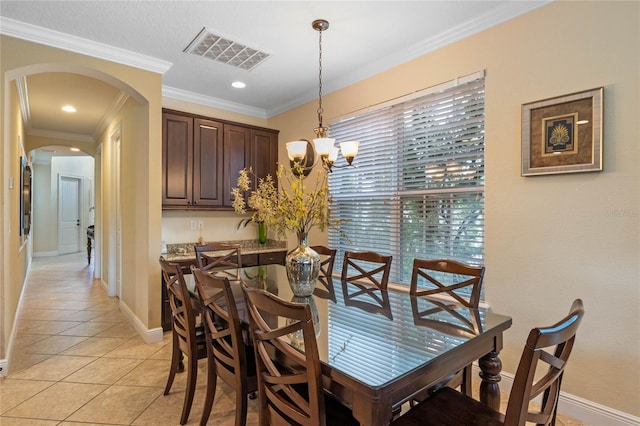 dining area with crown molding, a chandelier, and light tile floors