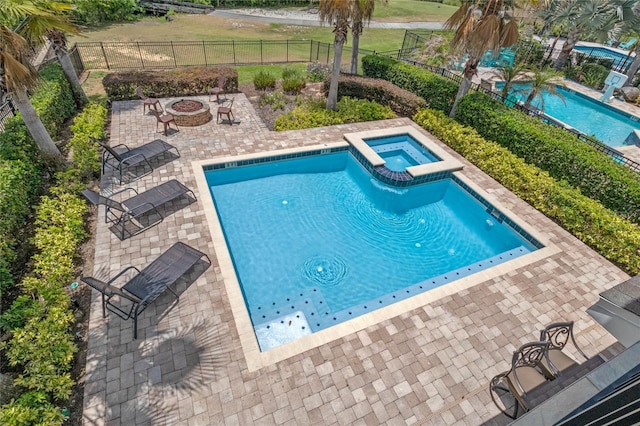 view of pool with an outdoor fire pit, a patio, an in ground hot tub, and a yard