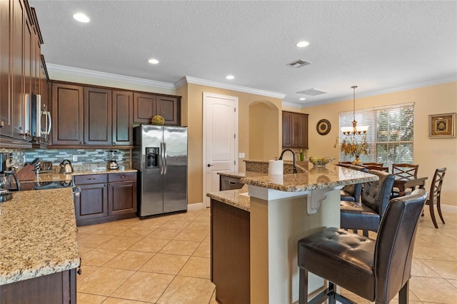 kitchen featuring a notable chandelier, hanging light fixtures, stainless steel appliances, and light stone countertops