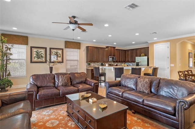 living room with ceiling fan and crown molding