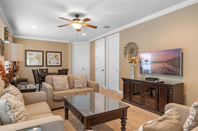 living room with crown molding, ceiling fan, and light colored carpet