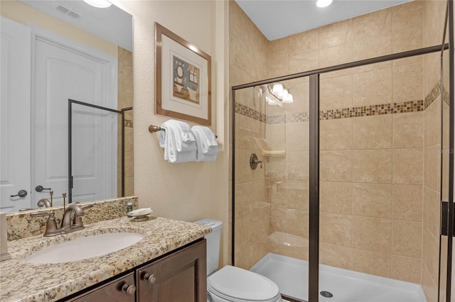 bathroom featuring walk in shower, toilet, and vanity