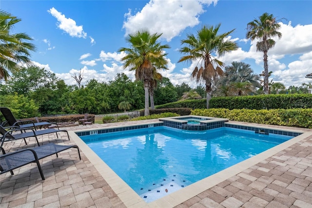 view of pool featuring a patio area and an in ground hot tub