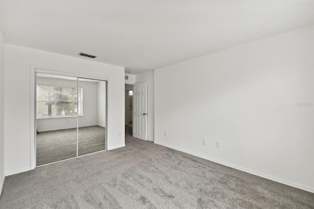unfurnished bedroom featuring carpet floors and a closet
