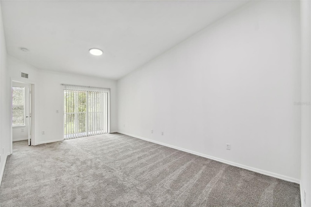 spare room featuring carpet floors and lofted ceiling