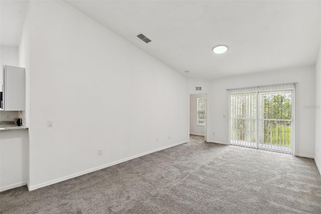 empty room with carpet flooring and lofted ceiling