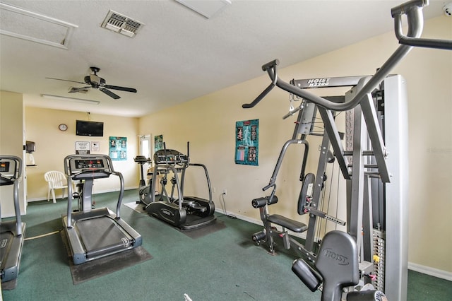 workout room with ceiling fan and a textured ceiling